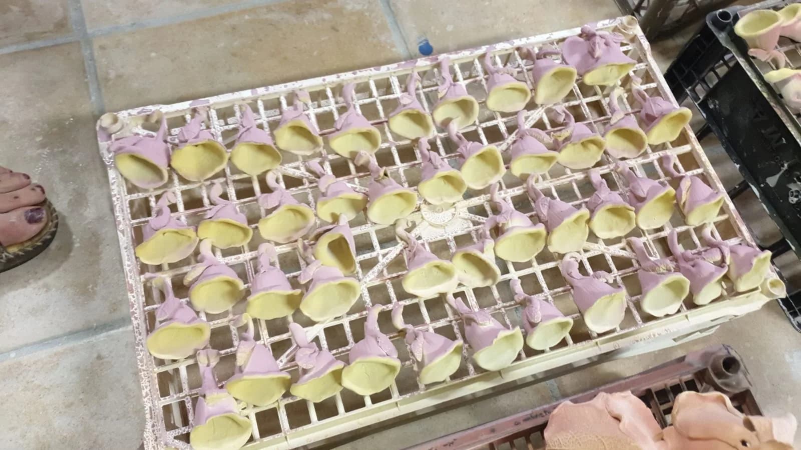 Vassoi di campanelle smaltate in fila, pronte per la cottura.