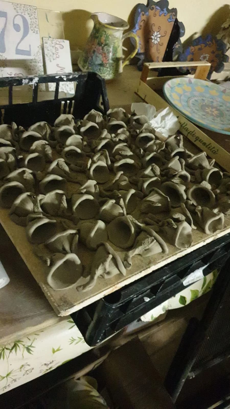 Campanelle di argilla cruda che asciugano sul vassoio.