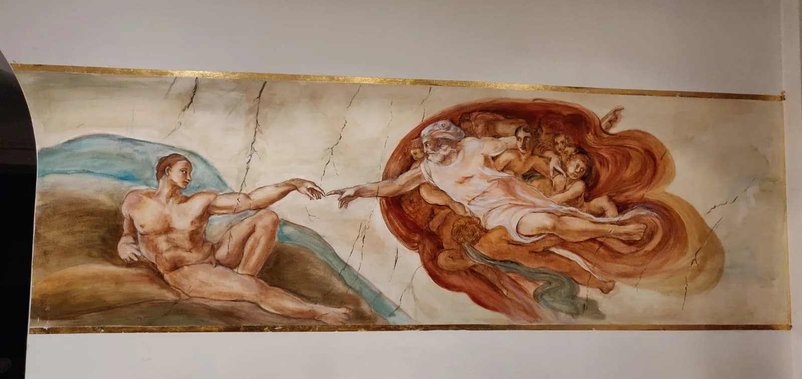 La Creazione di Adamo riportata su una fascia dipinta sopra le porte.