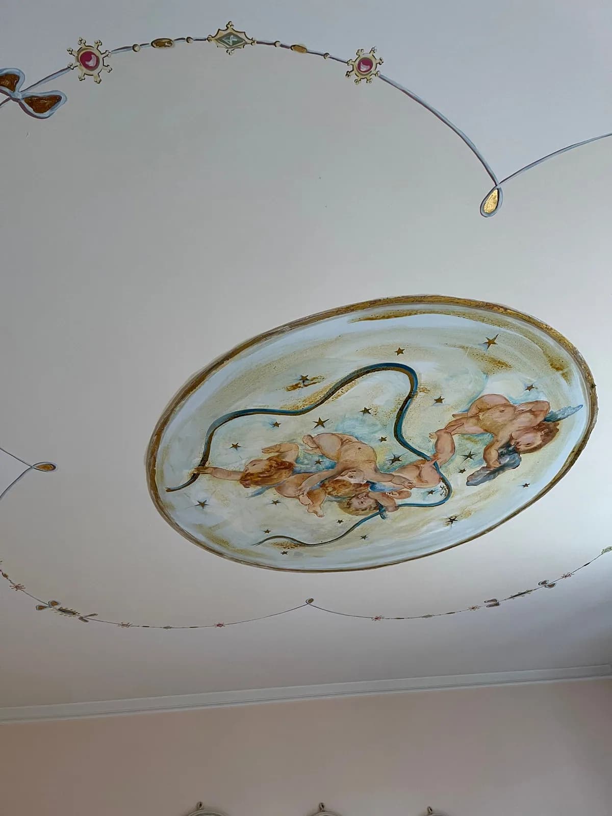 Un tondo dipinto al centro del soffitto di una camera, con il tralcio che lo contorna.