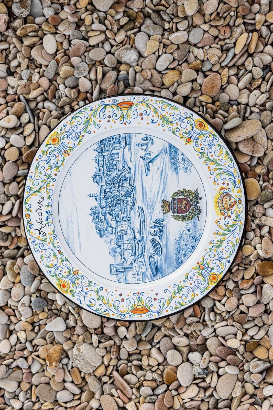 Maiolica plate dedicated to Ancona resting on the pebbles, with the Passetto drawn in the well.