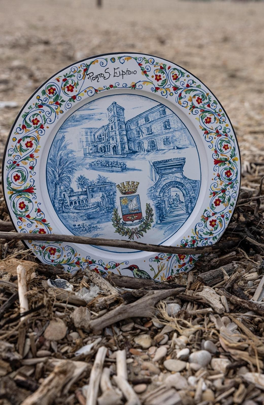 Maiolica plate dedicated to Porto Sant'Elpidio resting on wood carried in by the sea.