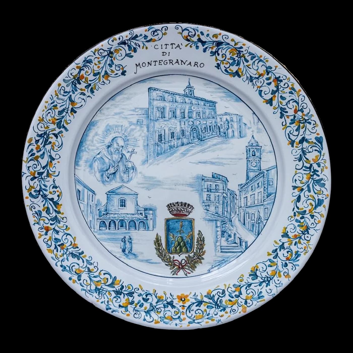 Piatto in maiolica dedicato a Montegranaro, con il palazzo comunale, la torre civica, la chiesa e lo stemma della città.