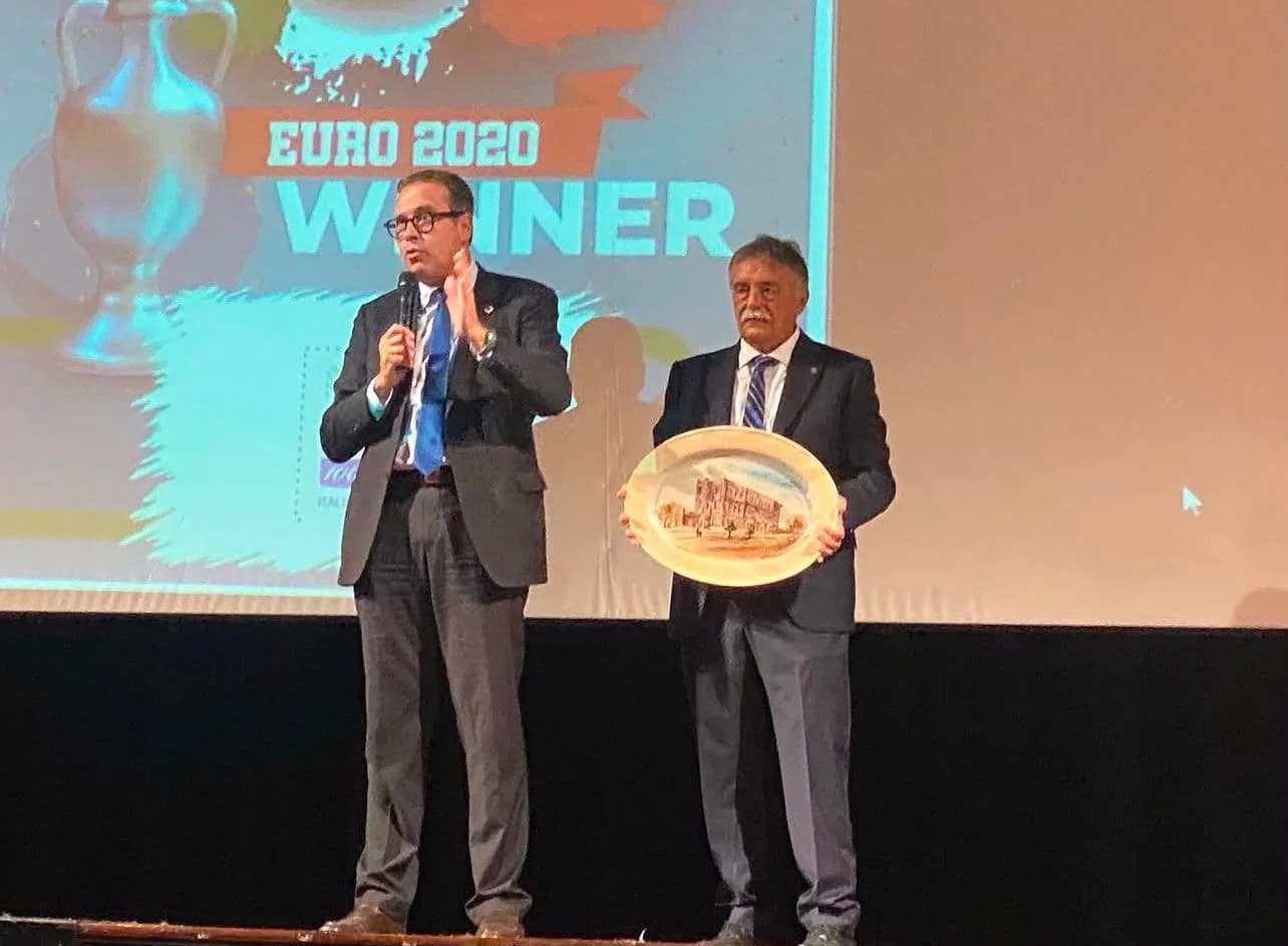 Sul palco, la consegna di un piatto ovale davanti a uno schermo con la scritta «Euro 2020 Winner».