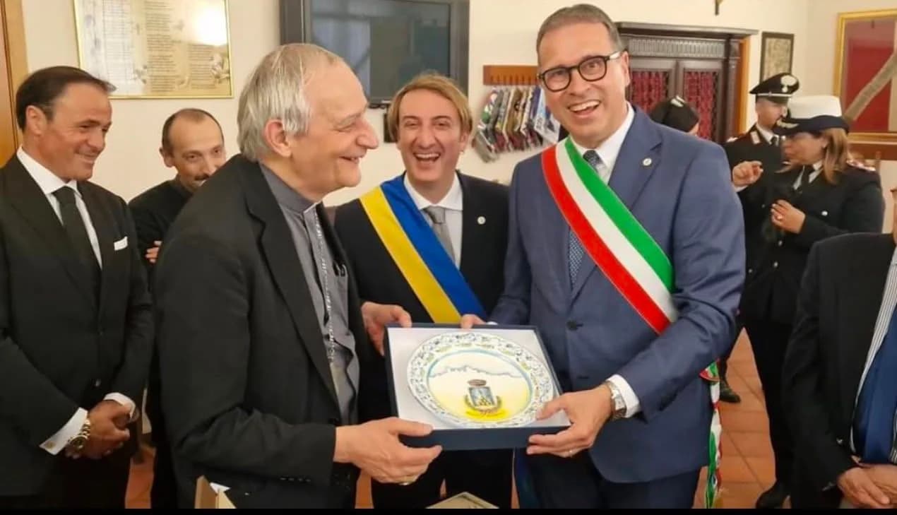 Cerimonia ufficiale: il piatto incorniciato passa di mano davanti alle autorità.