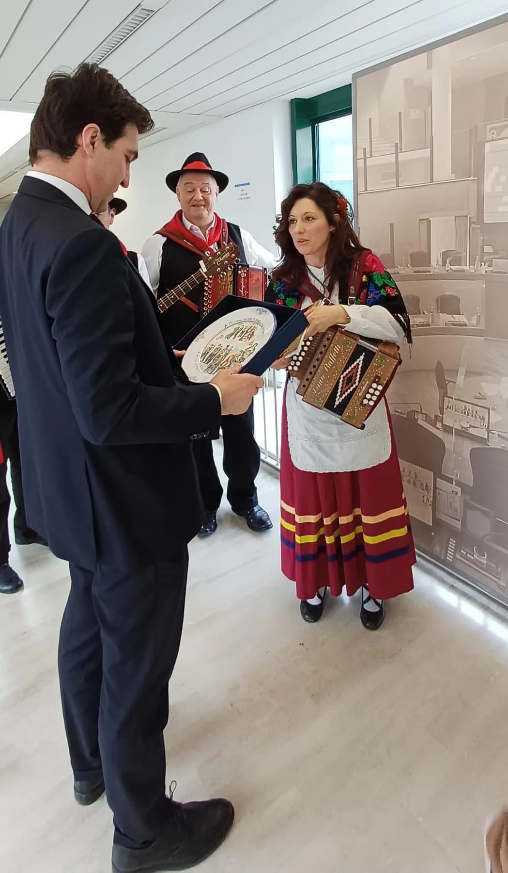 Nella sede del Consiglio Regionale delle Marche, il piatto in maiolica viene consegnato dentro il suo cofanetto, davanti ai musicisti in costume.